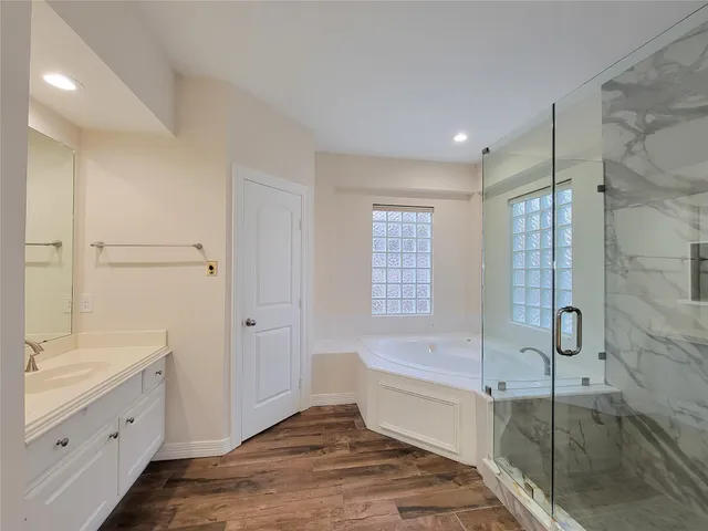 a spacious bathroom with a tub shower sink vanity and a mirror