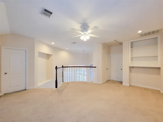 a view of an empty room with a ceiling fan