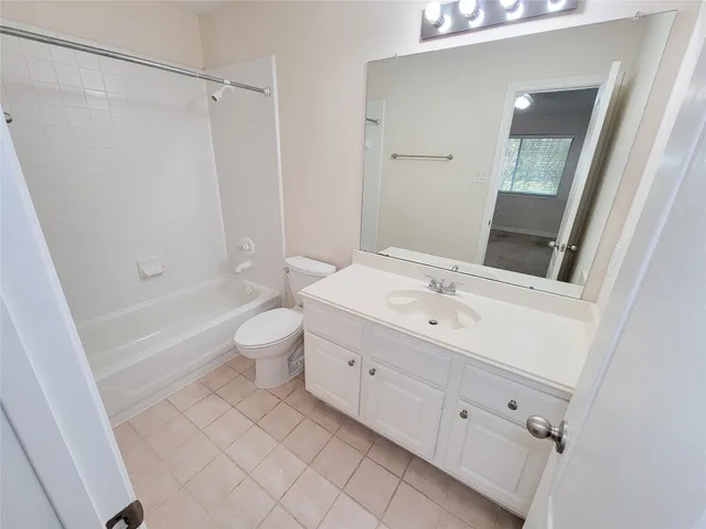 a bathroom with a double vanity sink toilet mirror and bathtub