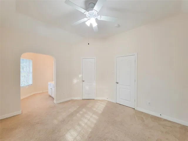an empty room with closet and a ceiling fan
