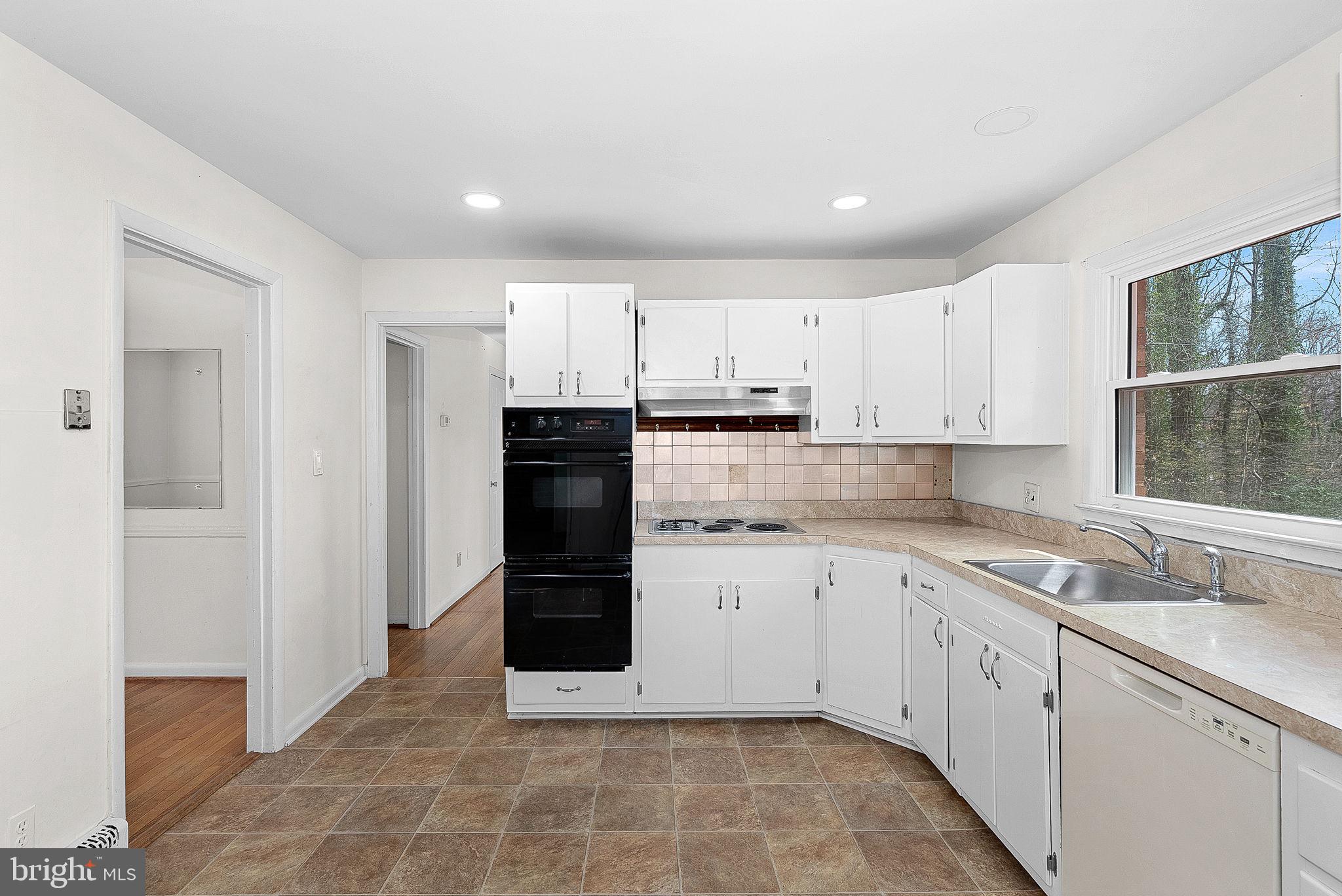 10021 Glenmere Road Fairfax, VA 22032 - Photo 12 of 45 a kitchen with white cabinets and appliances