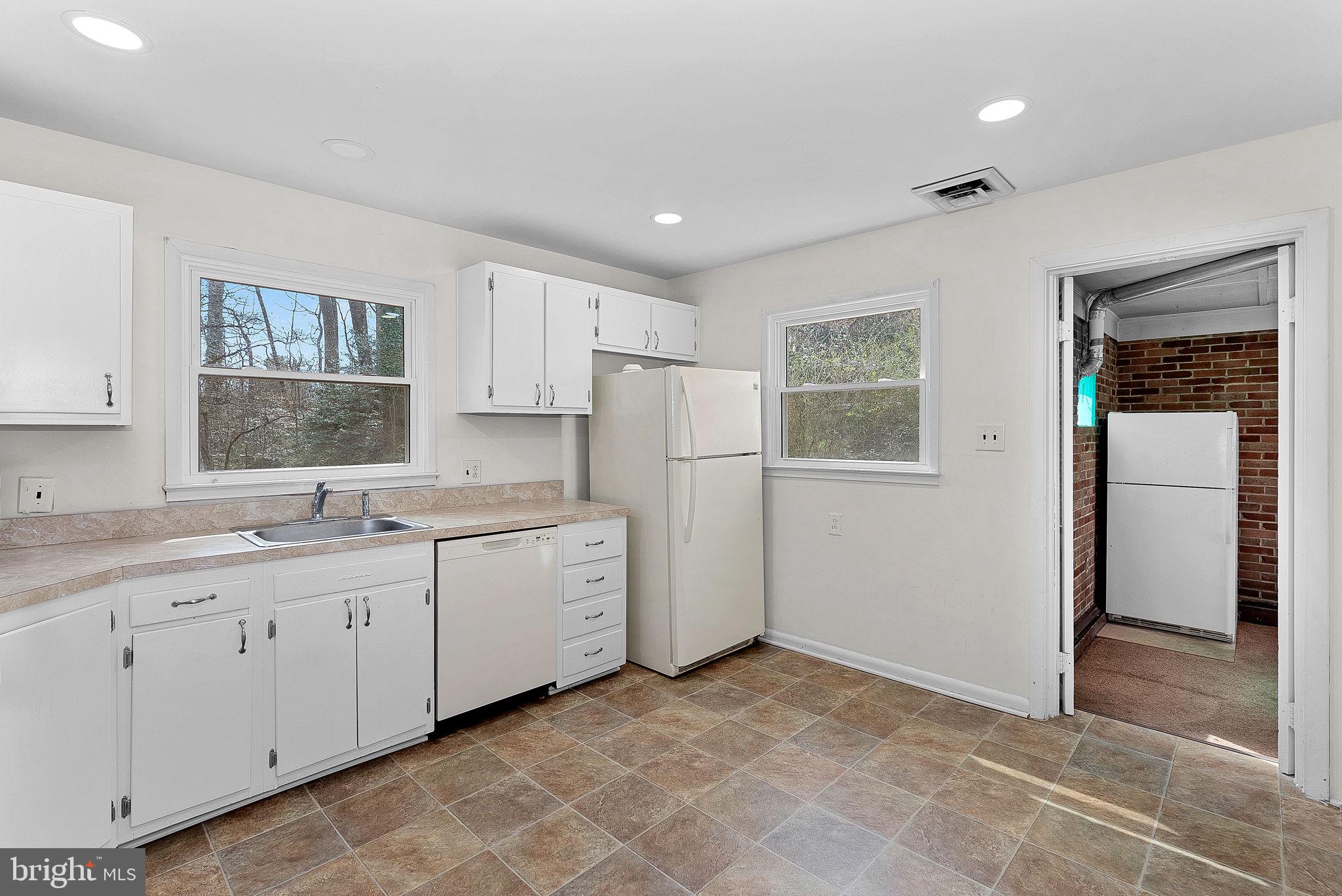 10021 Glenmere Road Fairfax, VA 22032 - Photo 13 of 45 a kitchen with white cabinets and white appliances
