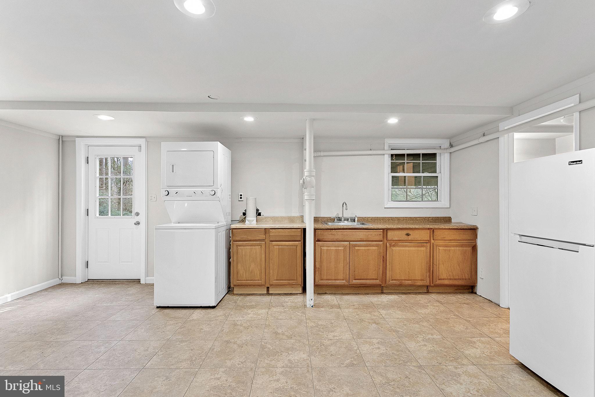 10021 Glenmere Road Fairfax, VA 22032 - Photo 28 of 45 a kitchen with a refrigerator and white cabinets
