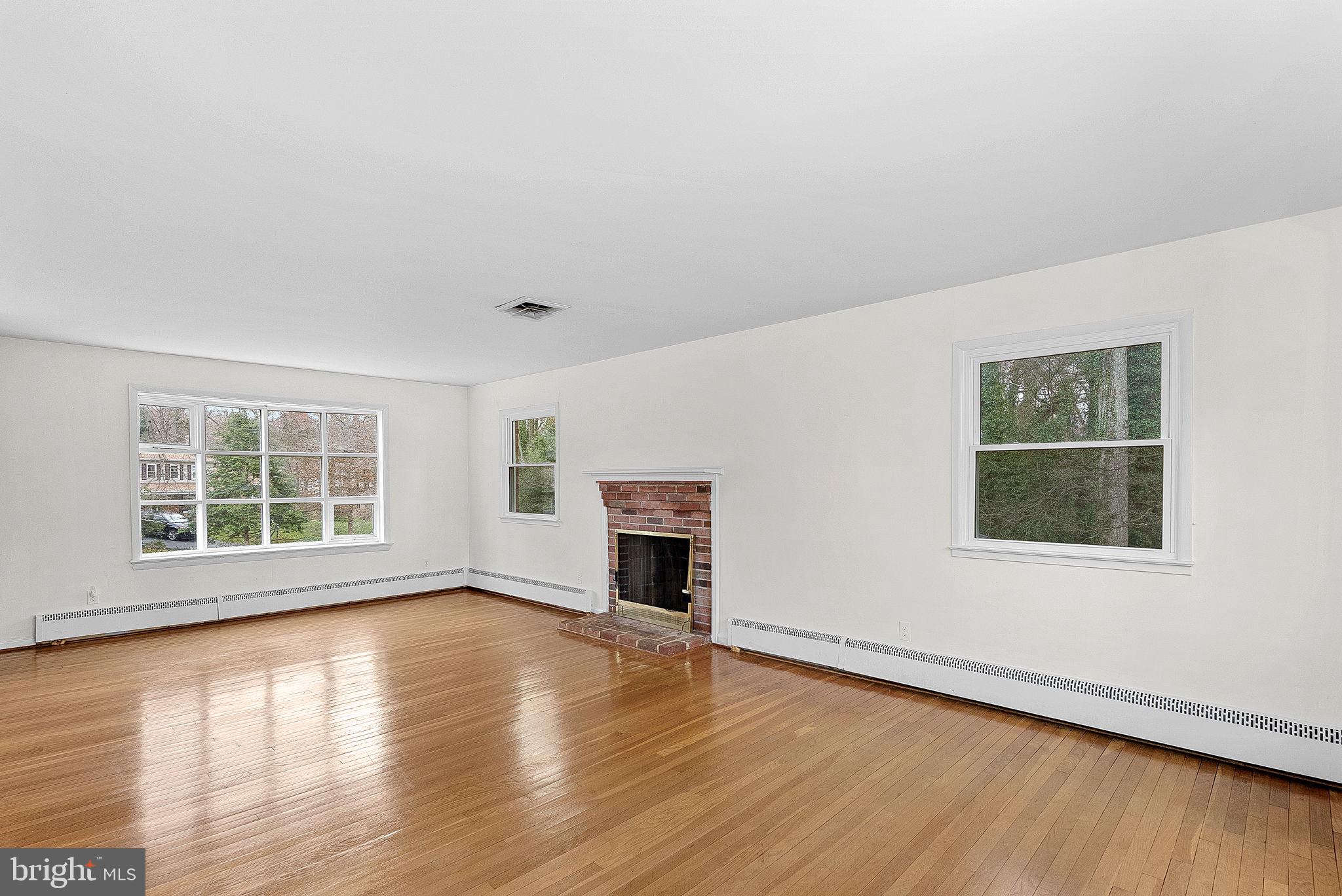 10021 Glenmere Road Fairfax, VA 22032 - Photo 5 of 45 an empty room with wooden floor fireplace and windows