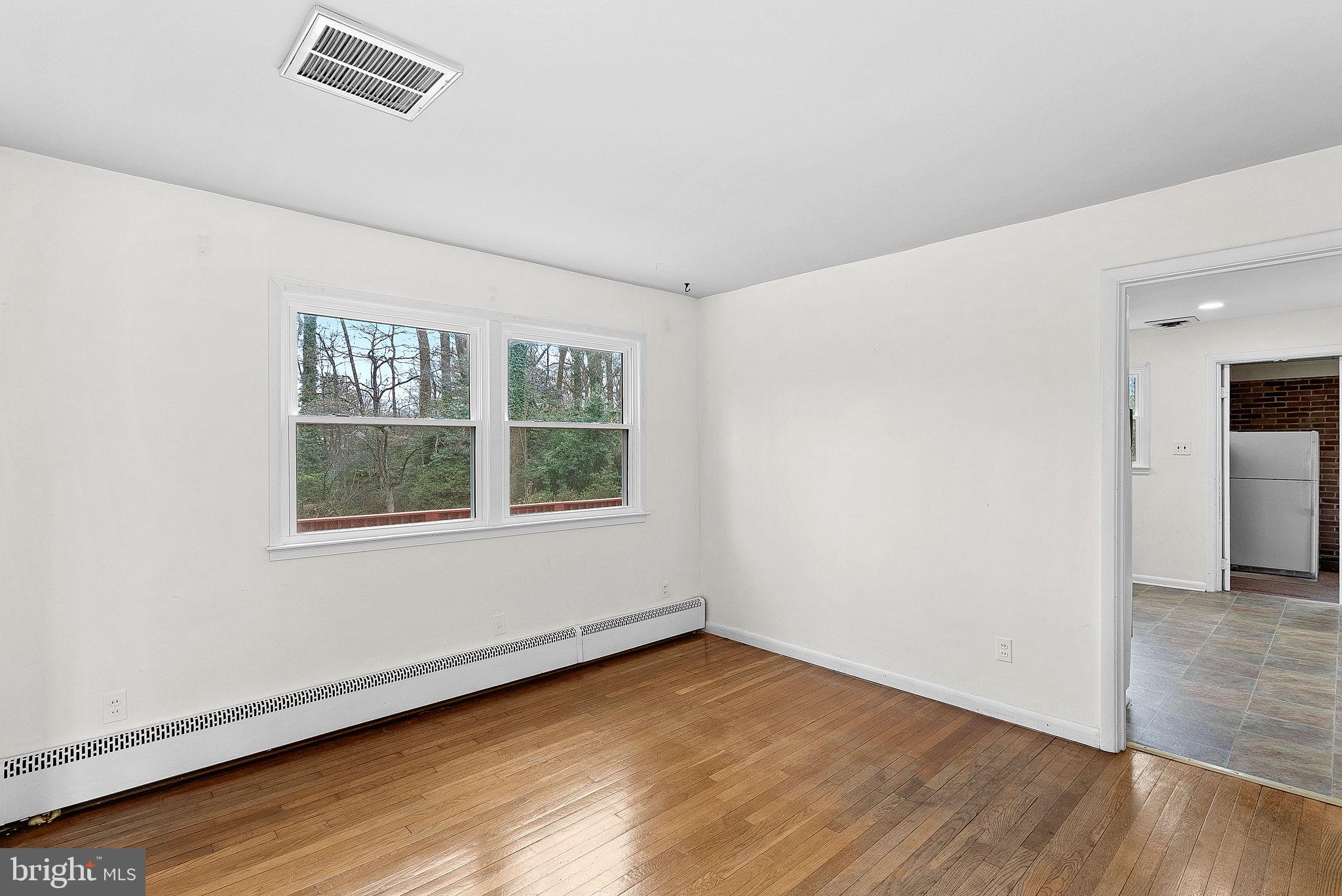 10021 Glenmere Road Fairfax, VA 22032 - Photo 8 of 45 an empty room with wooden floor and windows