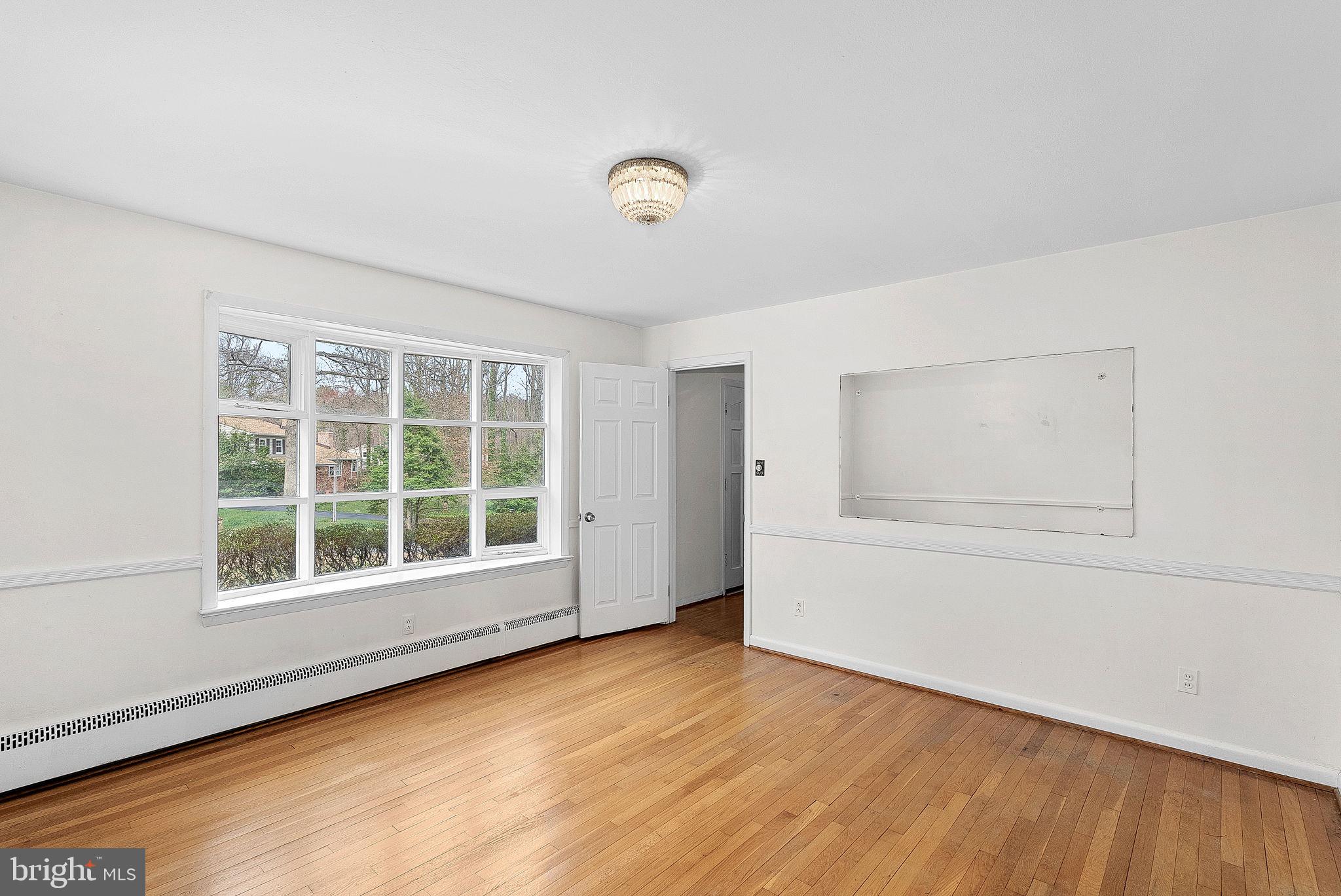 10021 Glenmere Road Fairfax, VA 22032 - Photo 9 of 45 an empty room with wooden floor and windows