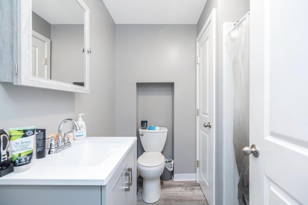 591 Grattan Street Chicopee, MA 01020 - Photo 10 of 36 a bathroom with a toilet a sink and mirror