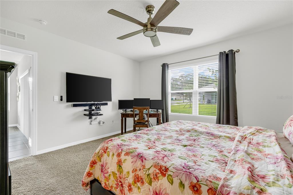 115 Duchess Road DeLand, FL 32724 - Photo 16 of 37 a bedroom with a bed and a flat screen tv