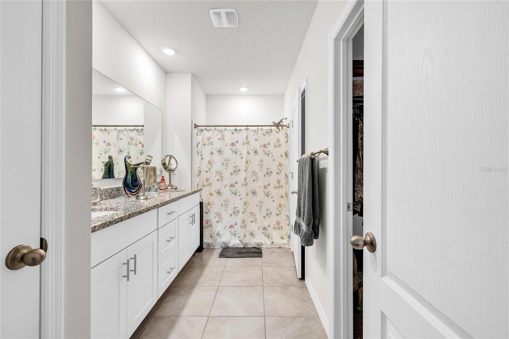 115 Duchess Road DeLand, FL 32724 - Photo 17 of 37 a bathroom with a granite countertop sink a mirror and shower