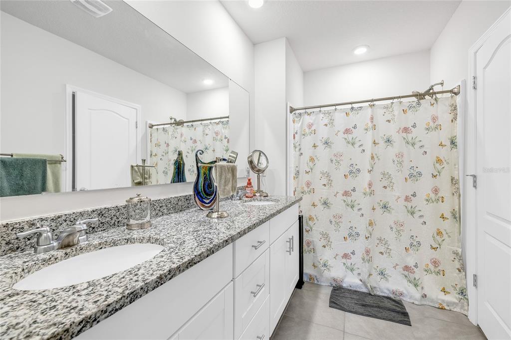 115 Duchess Road DeLand, FL 32724 - Photo 18 of 37 a bathroom with a granite countertop sink a toilet and a shower
