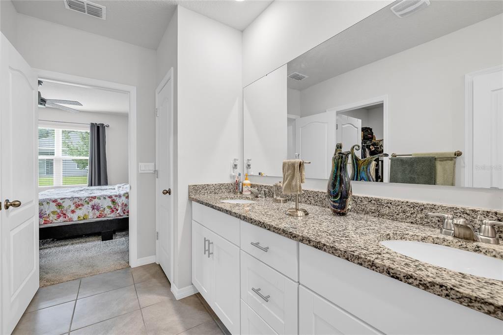 115 Duchess Road DeLand, FL 32724 - Photo 20 of 37 a en suite bathroom with a granite countertop sink and a mirror