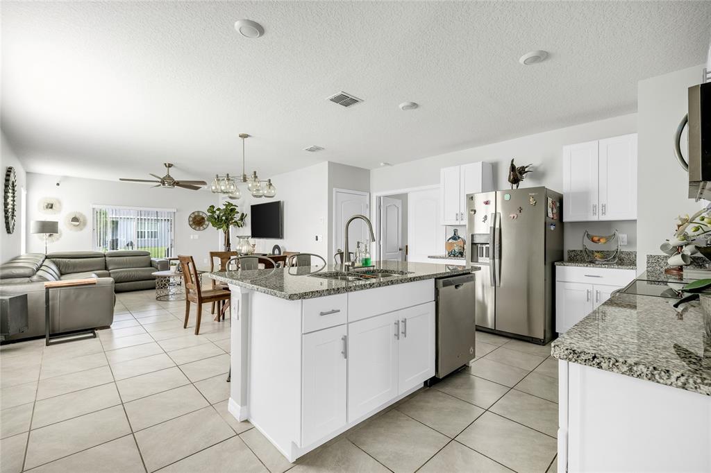 115 Duchess Road DeLand, FL 32724 - Photo 5 of 37 a kitchen with stainless steel appliances kitchen island granite countertop a sink and cabinets
