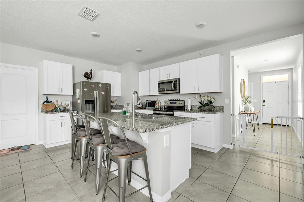 115 Duchess Road DeLand, FL 32724 - Photo 6 of 37 a kitchen with stainless steel appliances a refrigerator sink and cabinets