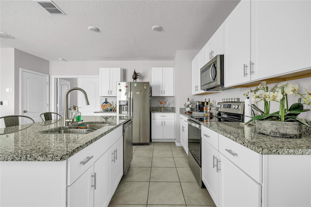 115 Duchess Road DeLand, FL 32724 - Photo 7 of 37 a kitchen with stainless steel appliances granite countertop a sink stove and cabinets