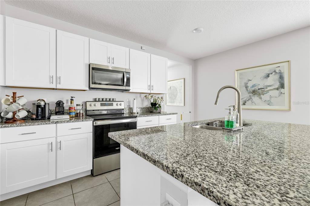 115 Duchess Road DeLand, FL 32724 - Photo 8 of 37 a kitchen with sink a stove and cabinets