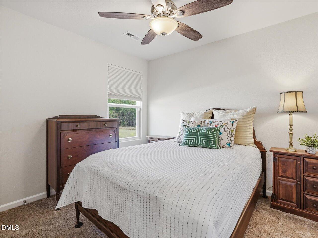 90 Barnsley Road Angier, NC 27501 - Photo 24 of 40 a bedroom with a bed and a chandelier