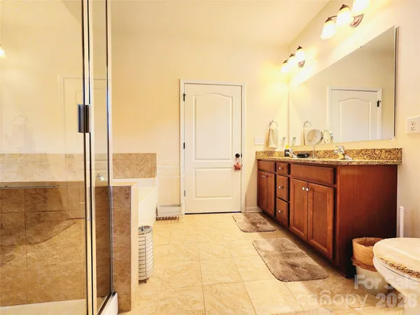 a bathroom with a sink toilet a mirror and shower