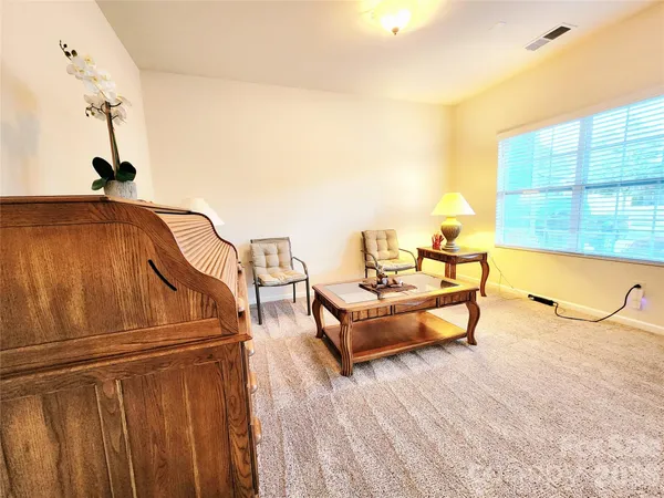 a kitchen with stainless steel appliances granite countertop a stove a sink a dining table chairs and white cabinets