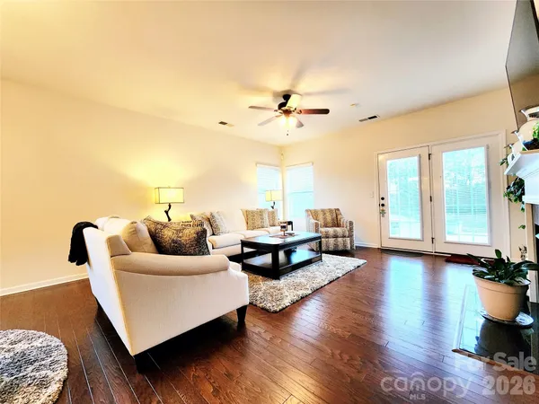 a living room with stainless steel appliances kitchen island granite countertop furniture a rug and a view of kitchen