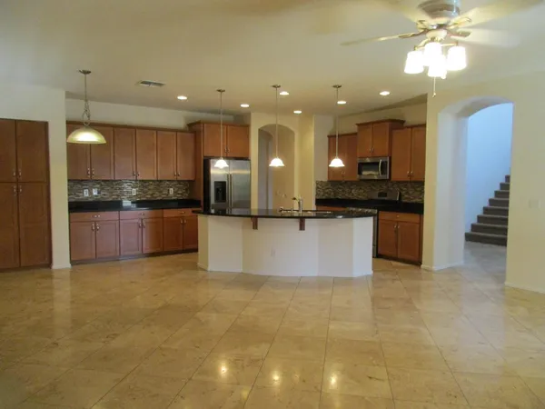 a large kitchen with a chandelier and stainless steel appliances