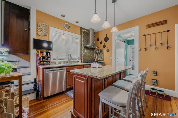 a kitchen with stainless steel appliances granite countertop a sink a stove and a refrigerator