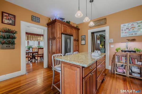 a kitchen that has a table chairs in it and wooden floor