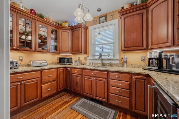 a kitchen with stainless steel appliances granite countertop wooden cabinets a sink and dishwasher