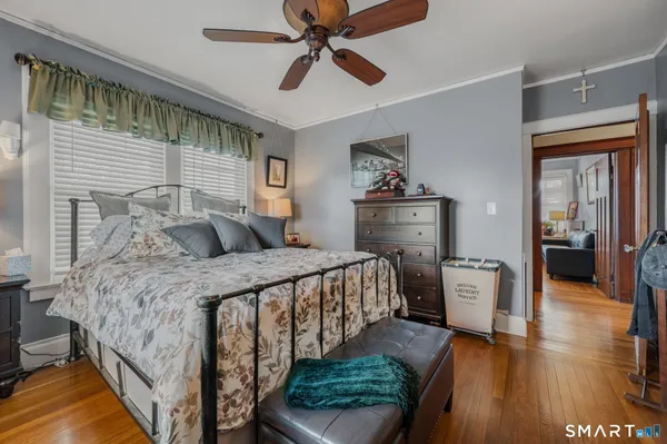 a bedroom with a bed and wooden floor
