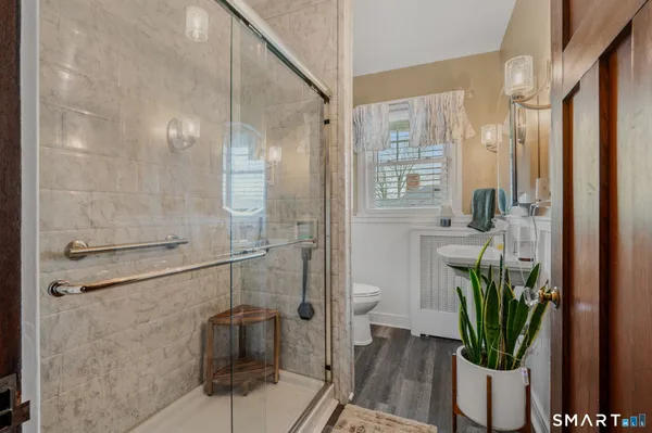 a bathroom with a shower a toilet and a sink