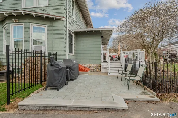 a backyard of a house with barbeque oven table and chairs