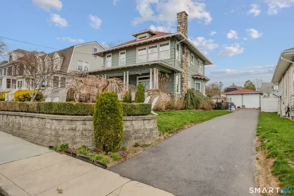 a front view of a house with a garden and plants