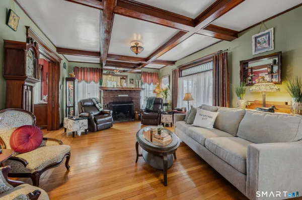 a living room with furniture a fireplace and large windows
