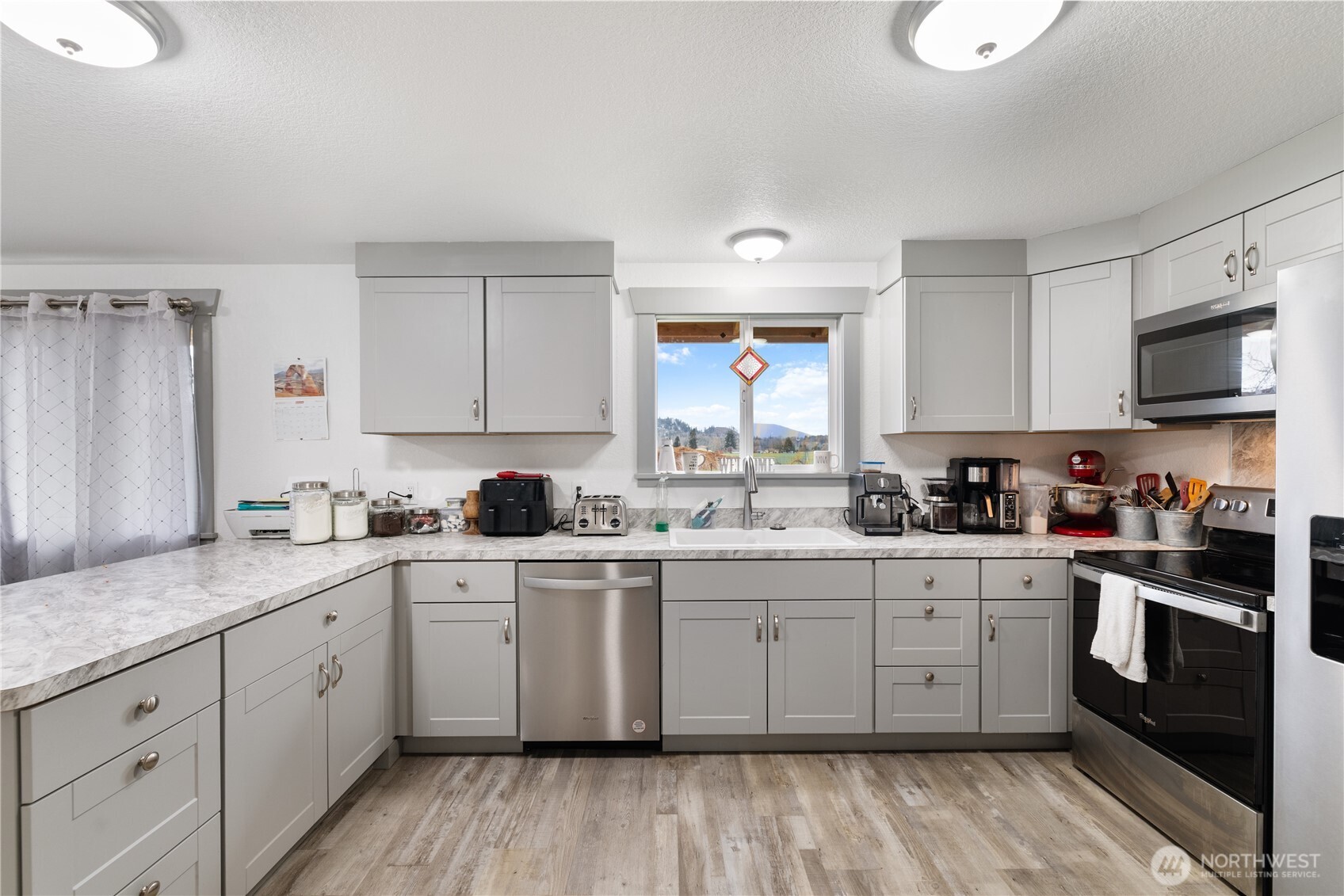21563-21567 Cook Road Sedro-Woolley, WA 98284 - Photo 29 of 38 a kitchen with a sink stove cabinets and wooden floor