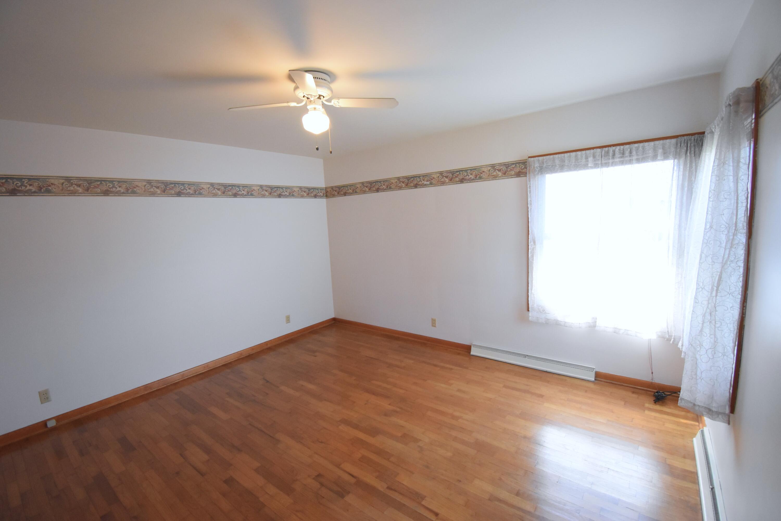 328 South Weston Street Rensselaer, IN 47978 - Photo 22 of 39 wooden floor in an empty room with a window
