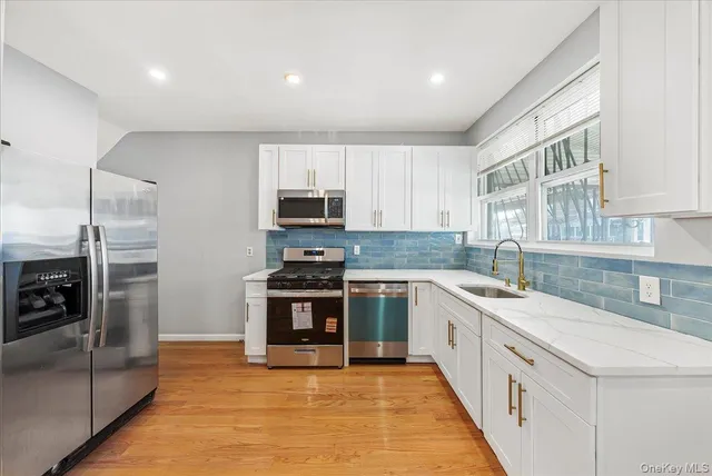 a large kitchen with stainless steel appliances granite countertop a large counter top and a stove top oven