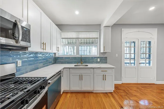 a large kitchen with stainless steel appliances granite countertop a stove a sink and a refrigerator