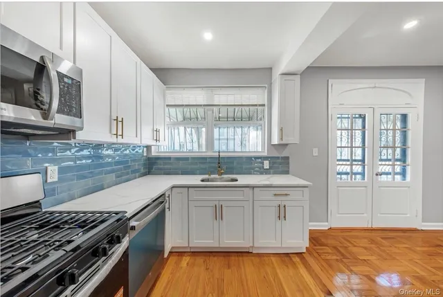 a kitchen with stainless steel appliances granite countertop a stove a sink and a refrigerator