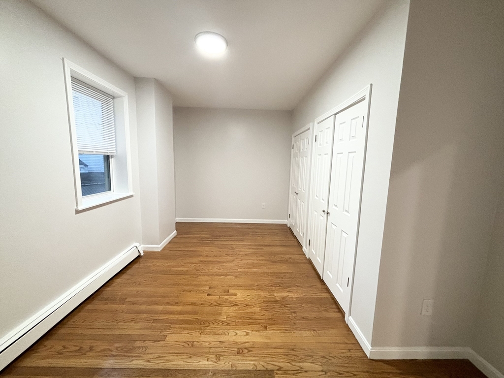 98 Main Street, Unit 1 Malden, MA 02148 - Photo 9 of 15 a view of an empty room with wooden floor and a window