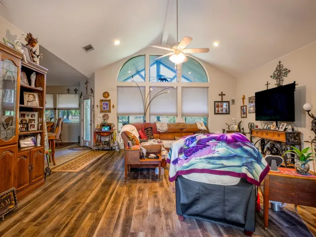 a living room with furniture a flat screen tv and kitchen view