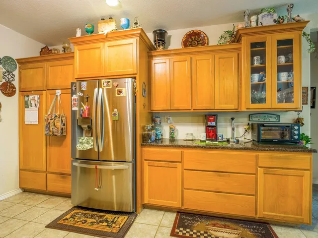 a kitchen with stainless steel appliances granite countertop a refrigerator and cabinets
