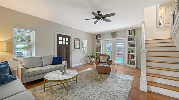 a kitchen with granite countertop a stove a refrigerator and a dining table with wooden floor