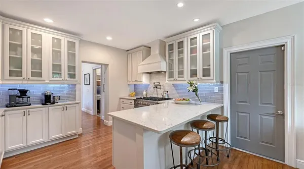 a kitchen with stainless steel appliances granite countertop a refrigerator a sink a stove and white cabinets