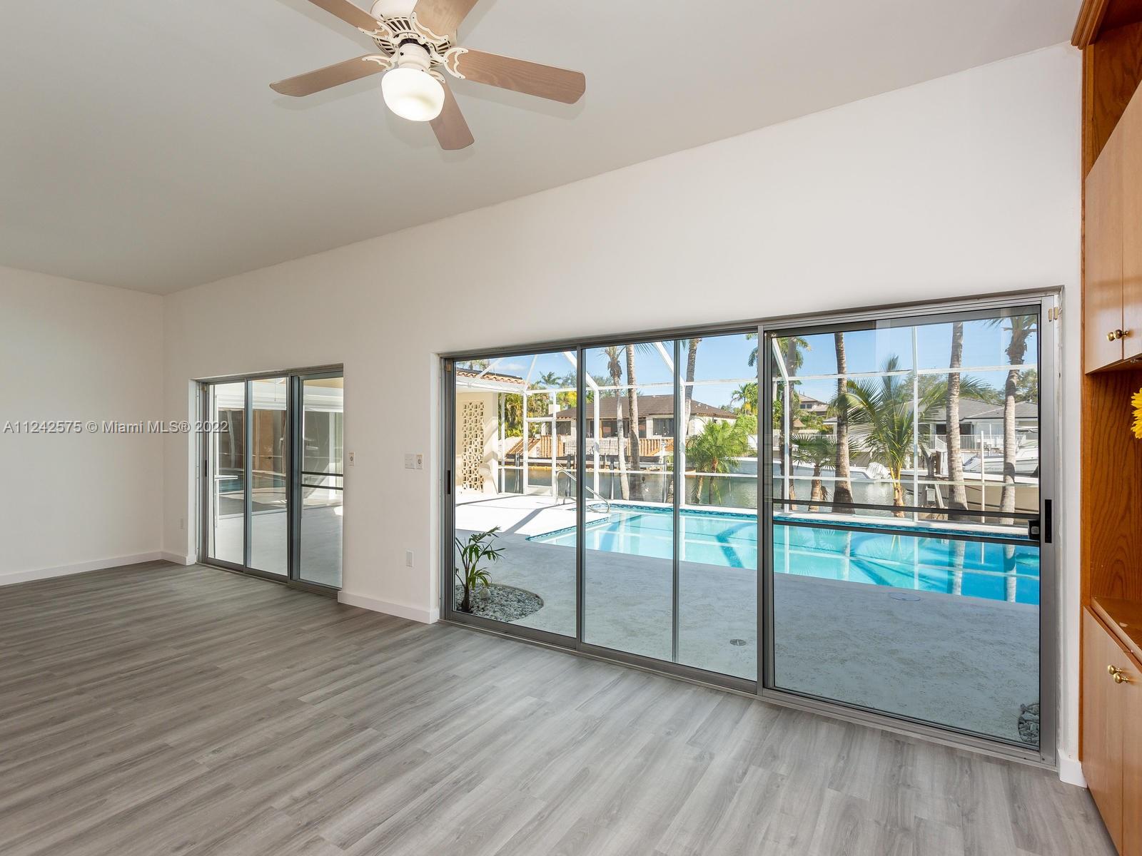 13001 Deva Street Coral Gables, FL 33156 - Photo 12 of 99 an empty room with wooden floor and windows