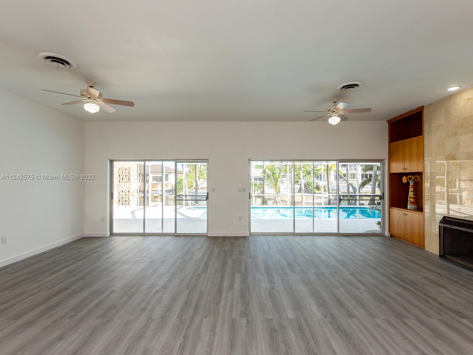 13001 Deva Street Coral Gables, FL 33156 - Photo 13 of 99 a view of an empty room with wooden floor and a window