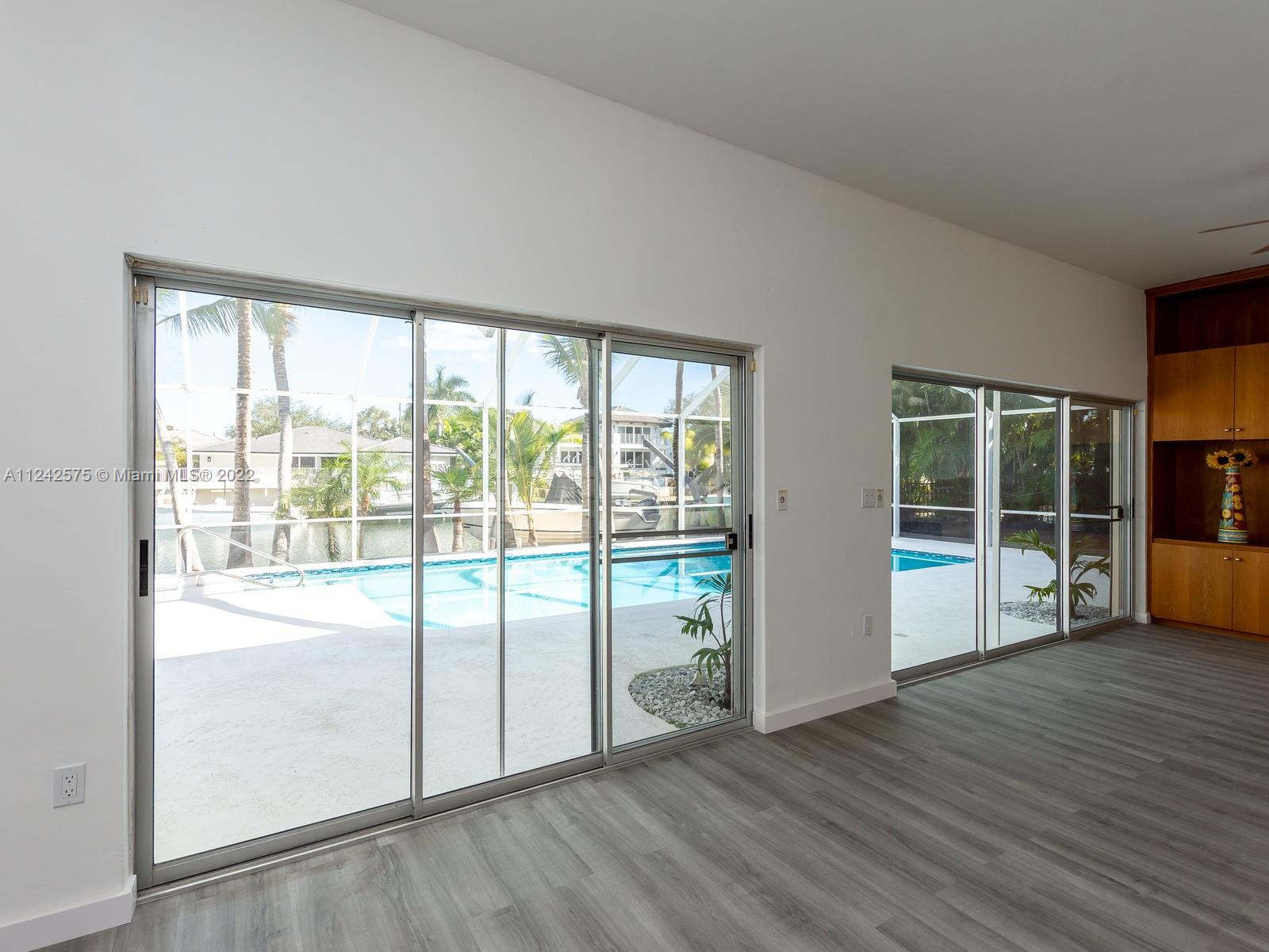 13001 Deva Street Coral Gables, FL 33156 - Photo 14 of 99 a view of an empty room with wooden floor and a window