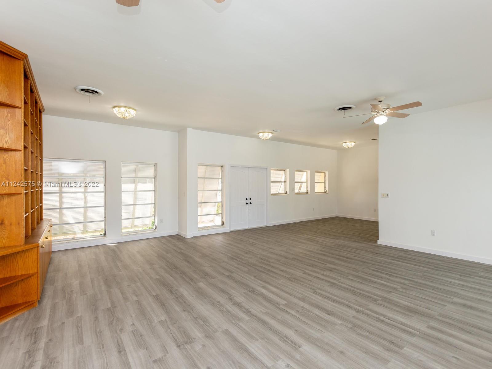 13001 Deva Street Coral Gables, FL 33156 - Photo 16 of 99 a view of an empty room with a window and wooden floor