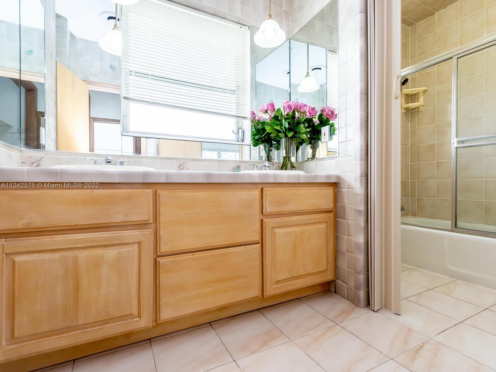 13001 Deva Street Coral Gables, FL 33156 - Photo 54 of 99 a bathroom with a granite countertop sink a mirror and a potted plant