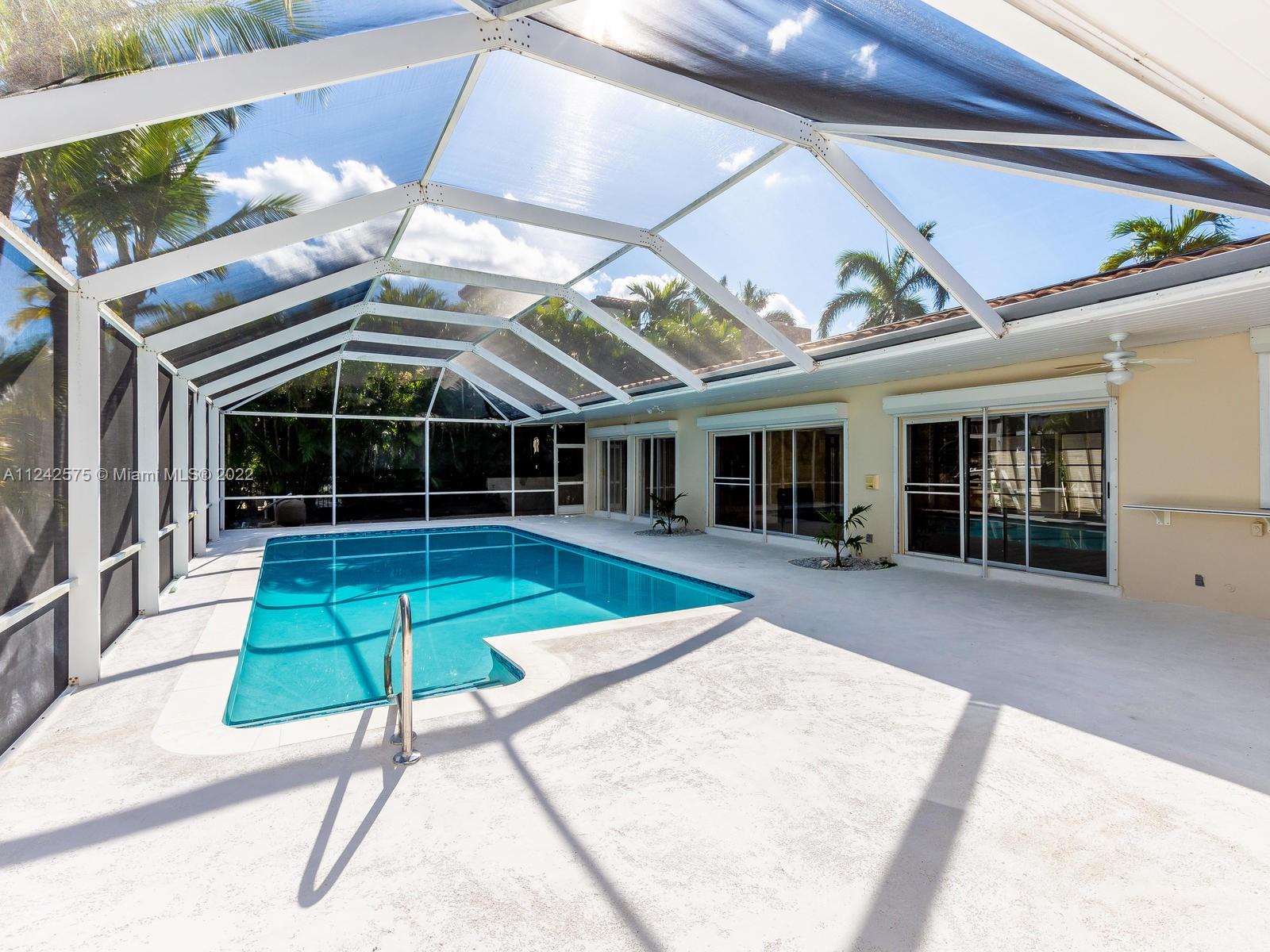13001 Deva Street Coral Gables, FL 33156 - Photo 71 of 99 a view of a patio with a table and chairs under an umbrella