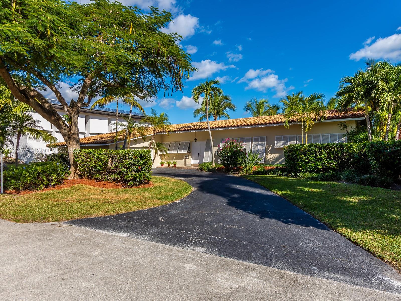 13001 Deva Street Coral Gables, FL 33156 - Photo 79 of 99 a front view of a house with a yard and garage