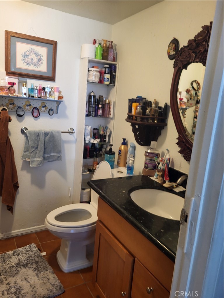 13141 Monroe Street Garden Grove, CA 92844 - Photo 14 of 21 a bathroom with a granite countertop toilet sink and mirror